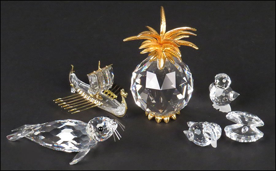 GROUP OF FIVE SWAROVSKI CRYSTAL FIGURES.: GROUP OF FIVE SWAROVSKI CRYSTAL FIGURES. Comprsied of a seal, two baby chicks, a ship with gilded oars, and an oyster shell. With a mirrored base. Together with a Swarovski crystal pinapple form paper