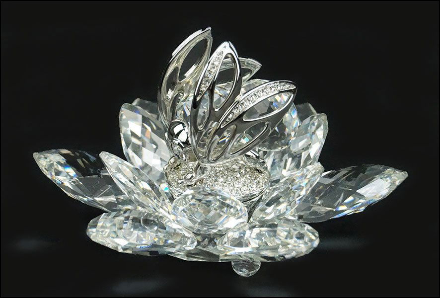 SWAROVSKI CRYSTAL 'IN FLIGHT RHODIUM BEE' FIGURE.: SWAROVSKI CRYSTAL 'IN FLIGHT RHODIUM BEE' FIGURE. Depicting a bee in the center of a lotus flower. Stamped beneath. 7553-200-0000 H: 2.25'' Width: 4''