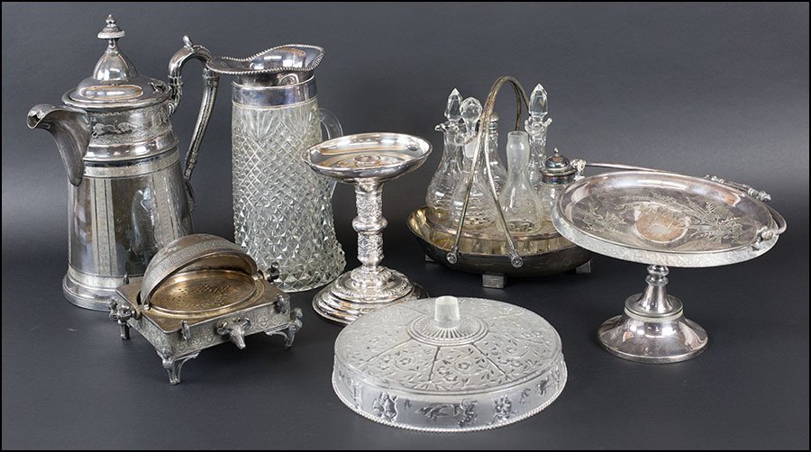 A COLLECTION OF SILVERPLATE TABLE ARTICLES.: A COLLECTION OF SILVERPLATE TABLE ARTICLES. Comprising a basket form cruet set, a glass pitcher with silverplate rim, a cheese dome, two compotes, and a kettle Kettle: 13.5"