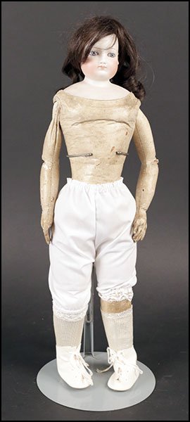 A JUMEAU BISQUE DOLL.: A JUMEAU BISQUE DOLL. Incised with a number 5 on the shoulder plate. Bearing a hard leather body, set paperweight eyes, and pierced ears. Unmarked H: 20''