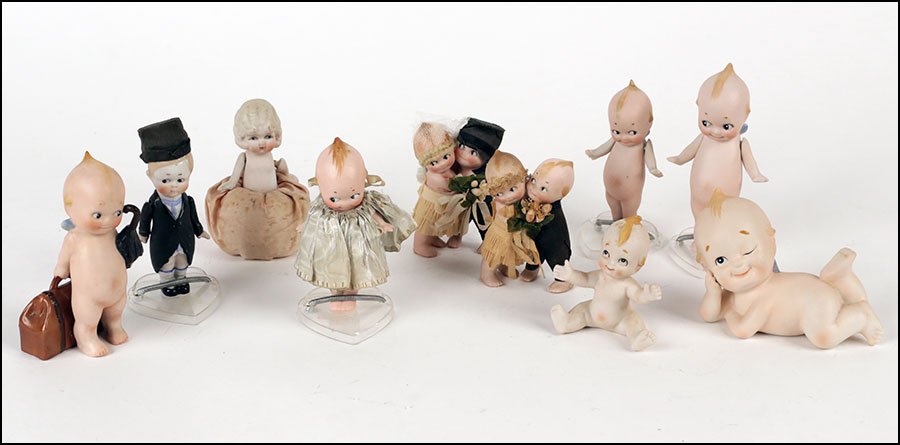 A COLLECTION OF KEWPIE BISQUE PORCELAIN FIGURAL DOLLS.: A COLLECTION OF KEWPIE BISQUE PORCELAIN FIGURAL DOLLS. Including two groups depicting a bride and groom, five babies, a bride and a groom, and others. Some stamped, some in stands