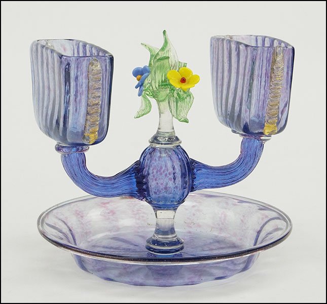 A STEUBEN CLEAR BLUE GLASS DOUBLE CIGARETTE STAND.: A STEUBEN CLEAR BLUE GLASS DOUBLE CIGARETTE STAND. Two oblong cigarette cups branch out from a central stem with a lampwork style clear green and multi-colored flower composition. Attached blue bowl b