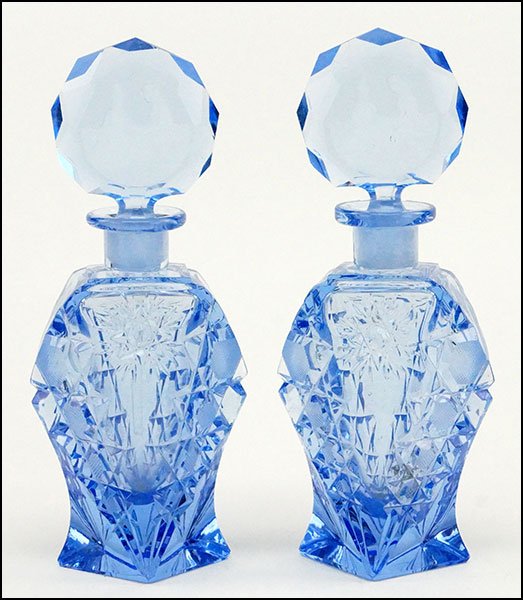 A PAIR OF CUT GLASS PERFUME BOTTLES.: A PAIR OF CUT GLASS PERFUME BOTTLES. Bearing etched cameo style stoppers Each: 7.5" x 3"