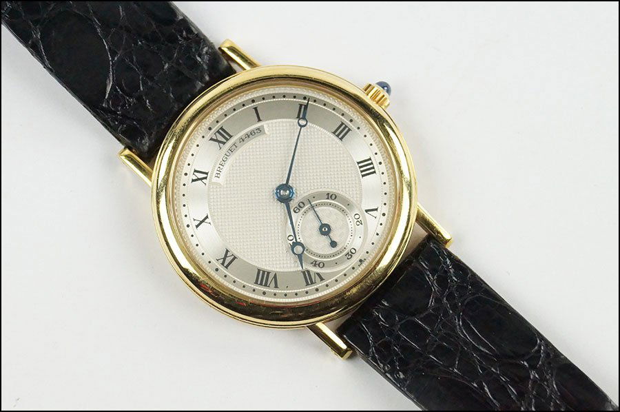 A BREGUET 18 KARAT YELLOW GOLD LADY'S WATCH.: A BREGUET 18 KARAT YELLOW GOLD LADY'S WATCH. With a cabochon sapphire capstone. Clasp is 18 karat yellow gold. Reverse of case is stamped "Breguet 4463". With a Breguet alligator band Face: 36mm x 33.