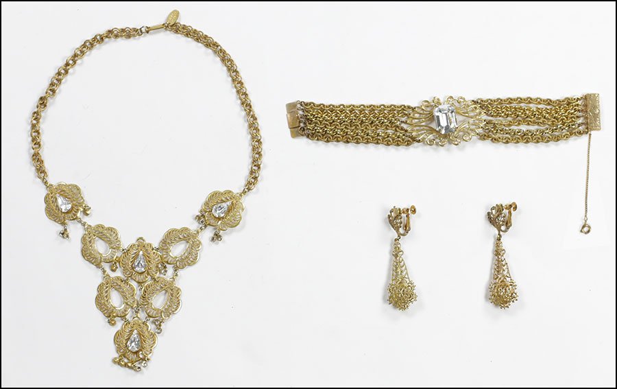 A MIRIAM HASKELL GOLDTONE AND WHITE RHINESTONE NECKLACE: A MIRIAM HASKELL GOLDTONE AND WHITE RHINESTONE NECKLACE. Together with a pair of earclips and a six strand metal link bracelet with white rhinestone center Necklace: 10"