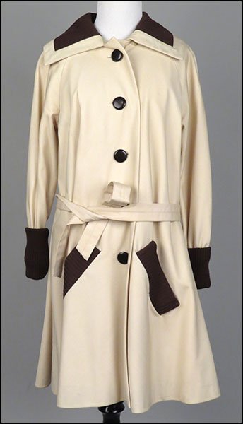 A PIERRE CARDIN FOR BONWIT TELLER TRENCHCOAT.: A PIERRE CARDIN FOR BONWIT TELLER TRENCHCOAT. With a self belt. With a knit brown trim at the collar and cuffs. Lined Size unlabeled