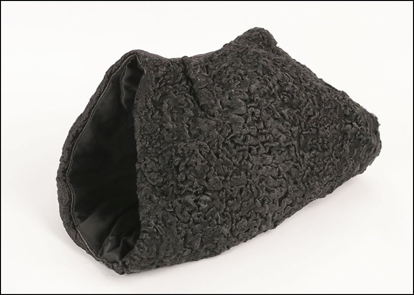 A BLACK PERSIAN LAMB MUFF.: A BLACK PERSIAN LAMB MUFF.