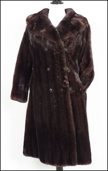 A THREE-QUARTER LENGTH MINK COAT.: A THREE-QUARTER LENGTH MINK COAT. With a double breasted rhinestone closure, a suede interior belt