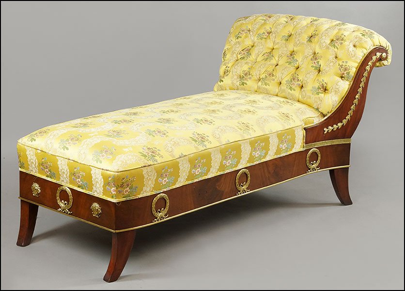 AN EMPIRE STYLE MAHOGANY AND GILT CHAISE LOUNGE.: AN EMPIRE STYLE MAHOGANY AND GILT CHAISE LOUNGE. Bearing tufted upholstery and applied medusa, wreath, and acanthus decoration to the sides 35'' x 74'' x 36''