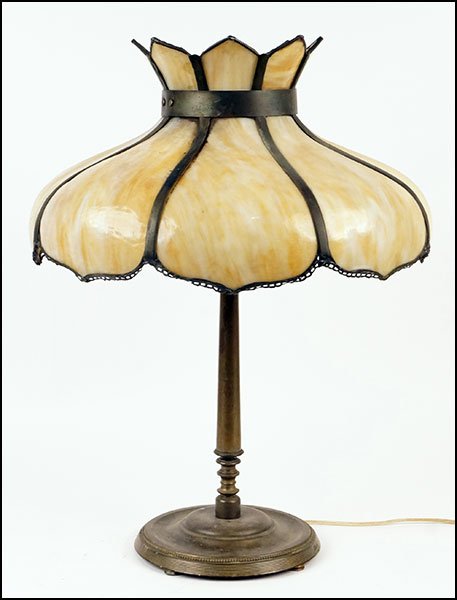 A SLAG GLASS AND PATINATED METAL OVERLAY TABLE LAMP.: A SLAG GLASS AND PATINATED METAL OVERLAY TABLE LAMP. Bearing sand colored mottled glass H: 24'' Diameter: 17.5''