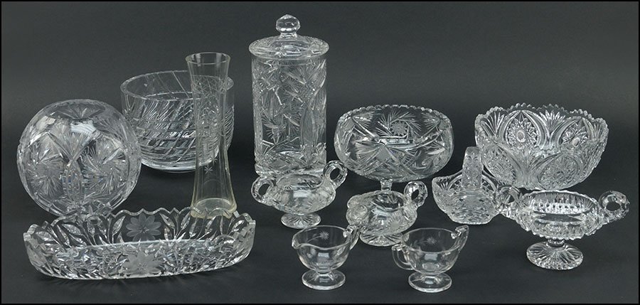 A COLLECTION OF CUT AND PRESSED GLASS TABLE ARTICLES.: A COLLECTION OF CUT AND PRESSED GLASS TABLE ARTICLES. Comprised of two serving bowls, a handled sugar bowl and creamer pitcher, a boule vase, a relish tray, a basket form bowl, a pitcher and creamer s