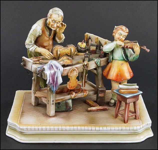 A BORSATO PORCELAIN FIGURAL GROUP.: A BORSATO PORCELAIN FIGURAL GROUP. Depicting a violin maker giving a lesson to a young girl. Signed on the back and the underside 9.25" x 11" x 7.5"
