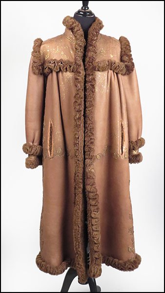 A FENDI FULL-LENGTH SHEARLING COAT.: A FENDI FULL-LENGTH SHEARLING COAT. Bearing a stand up collar, band cuffs, and a free form design throughout the garment. With a yoke gather design and a hook and eye closure Size unlabeled (approxima