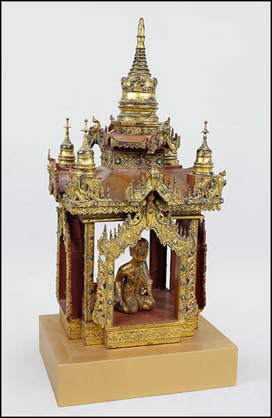 A TIBETAN CARVED SHRINE.: A TIBETAN CARVED SHRINE. Three pieces comprising a two-piece structure and a seated buddha figure within. All pieces are red laquered with gold overpainting and bear colored, mirrored glass tile embel