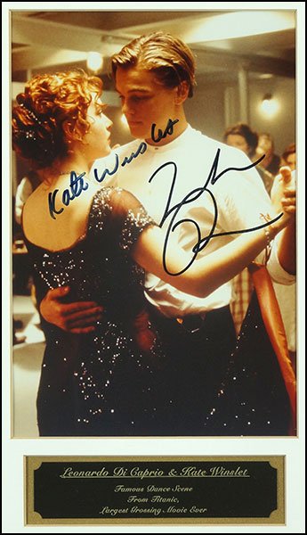 A SIGNED PHOTOGRAPH OF KATE WINSLET AND LEONARDO: A SIGNED PHOTOGRAPH OF KATE WINSLET AND LEONARDO DICAPRIO. Framed, with signatures on the color photo, and a nameplate below, bearing 'Leonardo Di Caprio & Kate Winslet Famous Date Scene from Titanic,