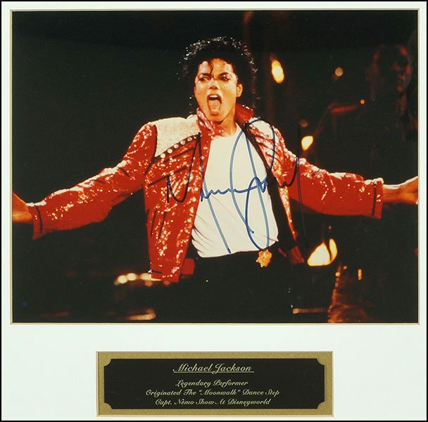 A MICHAEL JACKSON SIGNED PHOTOGRAPH.: A MICHAEL JACKSON SIGNED PHOTOGRAPH. Framed, bearing the signature on the color photograph, with a name plate below bearing 'Michael Jackson, Legendary Performer, Originated the Moonwalk Dance Step, C