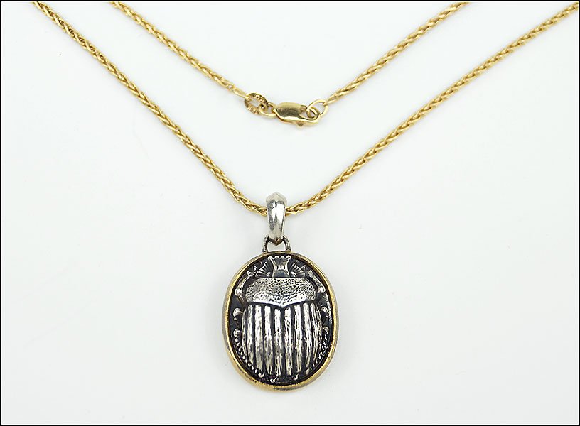 A DAVID YURMAN 22 KARAT YELLOW GOLD AND STERLING SILVER: A DAVID YURMAN 22 KARAT YELLOW GOLD AND STERLING SILVER SCARAB PENDANT. Stamped 'DY 925 22K' en verso. Together with a 14 karat yellow gold chain (length: 17") Pendant length: 1.25" Total Weight: 13.8
