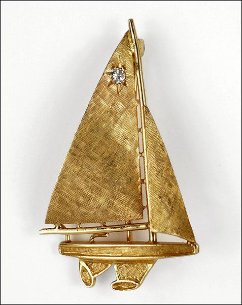 A DIAMOND AND 14 KARAT YELLOW GOLD SAILBOAT PIN.: A DIAMOND AND 14 KARAT YELLOW GOLD SAILBOAT PIN. Sail contains one round white diamond Length: 1.75" Weight: 5.5 grams