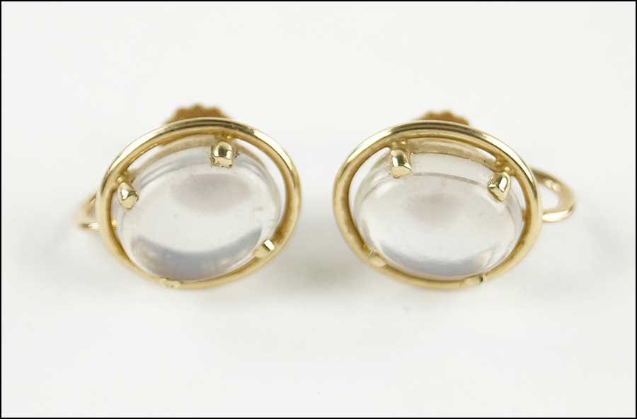A PAIR OF 14 KARAT YELLOW GOLD AND MOONSTONE EARRINGS.: A PAIR OF 14 KARAT YELLOW GOLD AND MOONSTONE EARRINGS. Containing one cabochon moonstone on each screwback earring Weight: 6.5 grams
