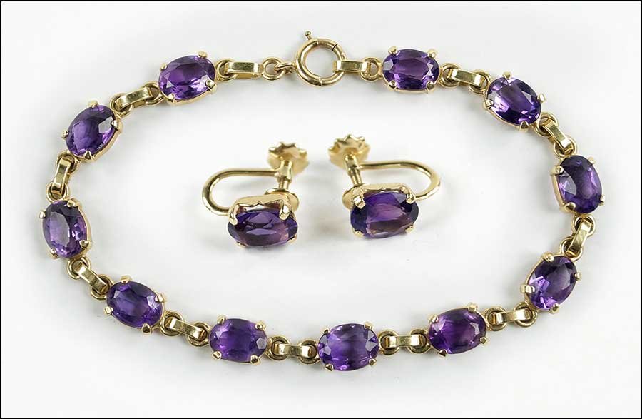 AN AMETHYST AND 14 KARAT YELLOW GOLD LINK BRACELET.: AN AMETHYST AND 14 KARAT YELLOW GOLD LINK BRACELET. Containing eleven prong set oval amethysts. Together with a pair of 14 karat yellow gold and amethyst screwback earrings Length: 7.5" Weight: 13.9 g