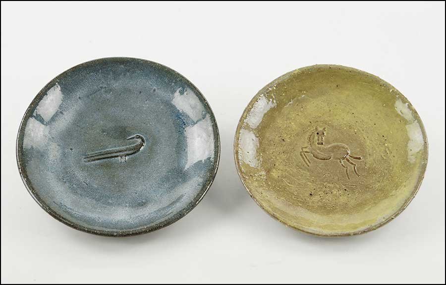 EUGENE DEUTCH (AMERICAN, 20TH CENTURY) TWO GLAZED: EUGENE DEUTCH (AMERICAN, 20TH CENTURY) TWO GLAZED POTTERY PLATES. One bears a bird figure in the bed and the other, a horse. Both are signed en verso and dated 1948 and 1947, respectively Each diamete