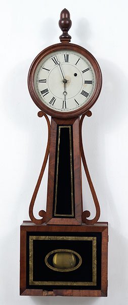 A Mahogany Banjo Style Clock.: A Mahogany Banjo Style Clock. Lower door and central panel bear eglomise decoration. The movement is not viewable, so the maker of the movement is not known. Susanin's will not comment on the working 