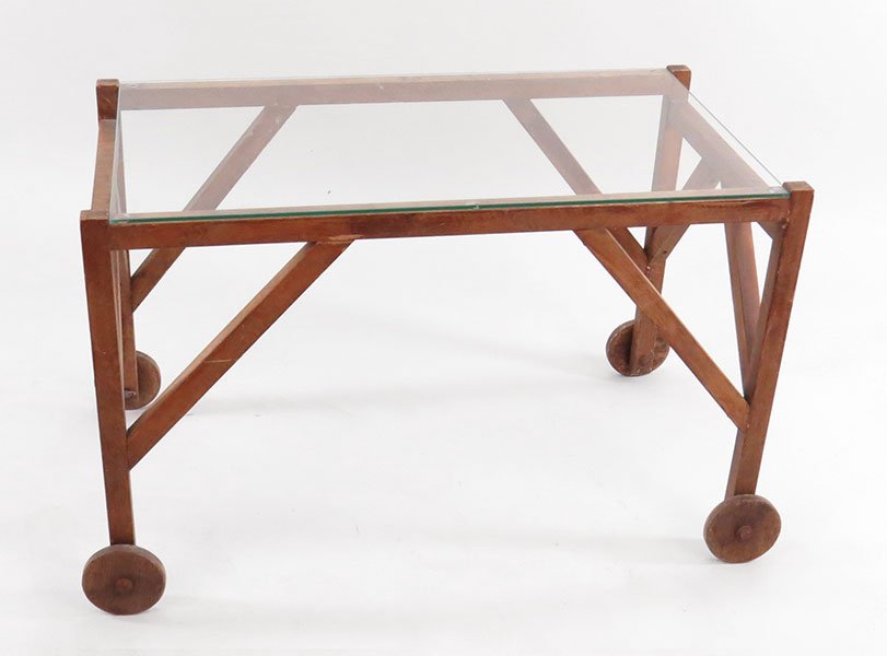 A Primitive Wood Rolling Cart.: A Primitive Wood Rolling Cart. With a glass top. Raised on four wood wheels H: 25" W: 39" D: 20.5"
