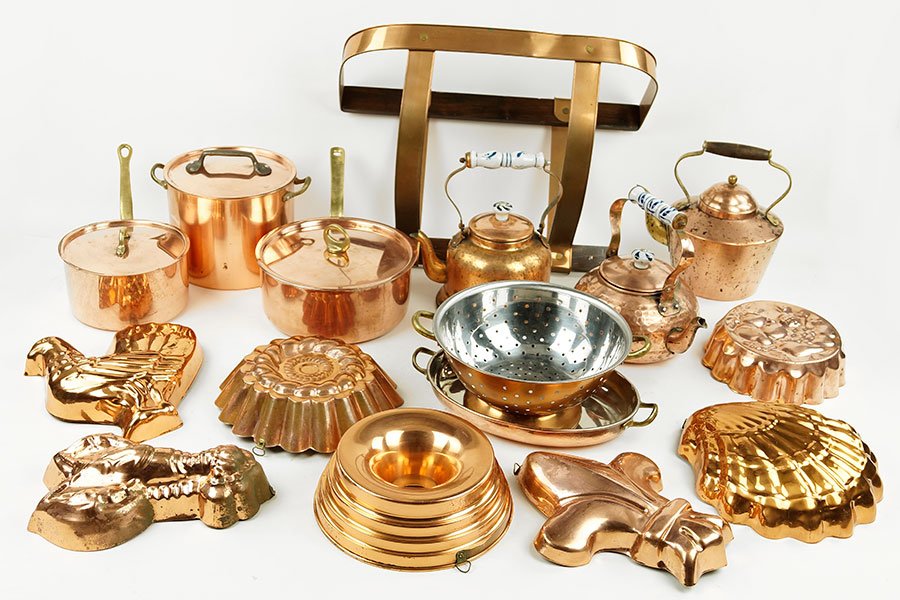 A Collection Of Copper Cookware.: A Collection Of Copper Cookware. Comprising seven molds, three kettles, two sauce pans, a colander, a wall mounted hot rack, and a small stock pot