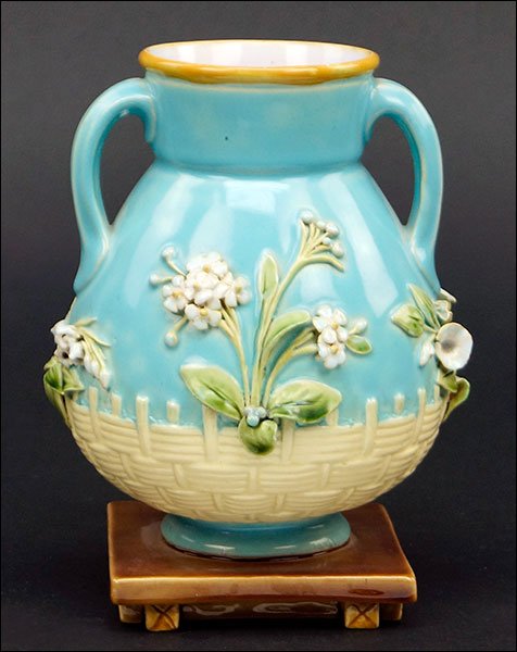 A Minton Majolica Handled Vase.: A Minton Majolica Handled Vase. Bearing raised floral and basket weave decoration. Raised on attached square base Height: 6.5"