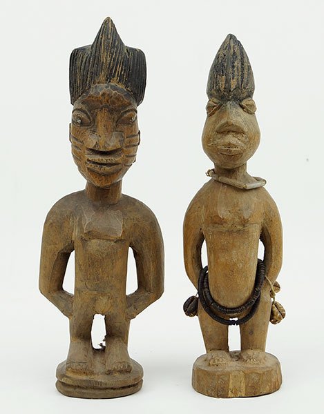A Pair Of African Carved Wood Ibeji Figures.: A Pair Of African Carved Wood Ibeji Figures. One male, one female. Female bears handmade beaded belt and bracelets Male Height: 10.75"