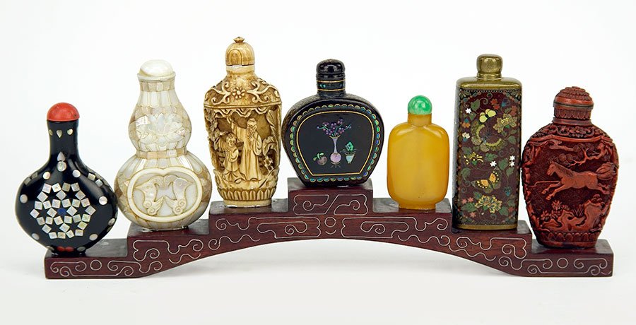 A Group of Seven Chinese Snuff Bottles.: A Group of Seven Chinese Snuff Bottles. Cloisonne, bone, cinnabar, peking glass, papier mache, and mother-of-pearl. Together with a snuff bottle stand