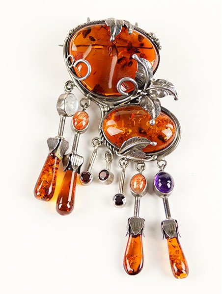 An Amber and Sterling Silver Brooch / Pendant.: An Amber and Sterling Silver Brooch / Pendant. Two amber stoned from which is suspended articulated amber drops with amethyst, garnet, and moonstone 4" x 2.5"