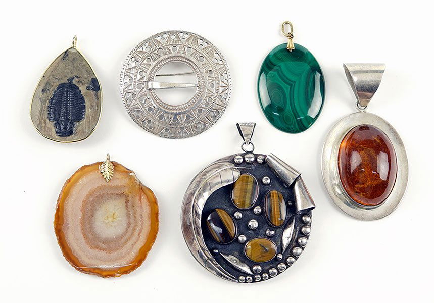 A Tiger's Eye and Sterling Silver Pendant.: A Tiger's Eye and Sterling Silver Pendant. Together with a David Andersen sterling silver brooch, an amber and sterling silver pendant, a malachite pendant, an agate pendant, and a fossil specimen pen
