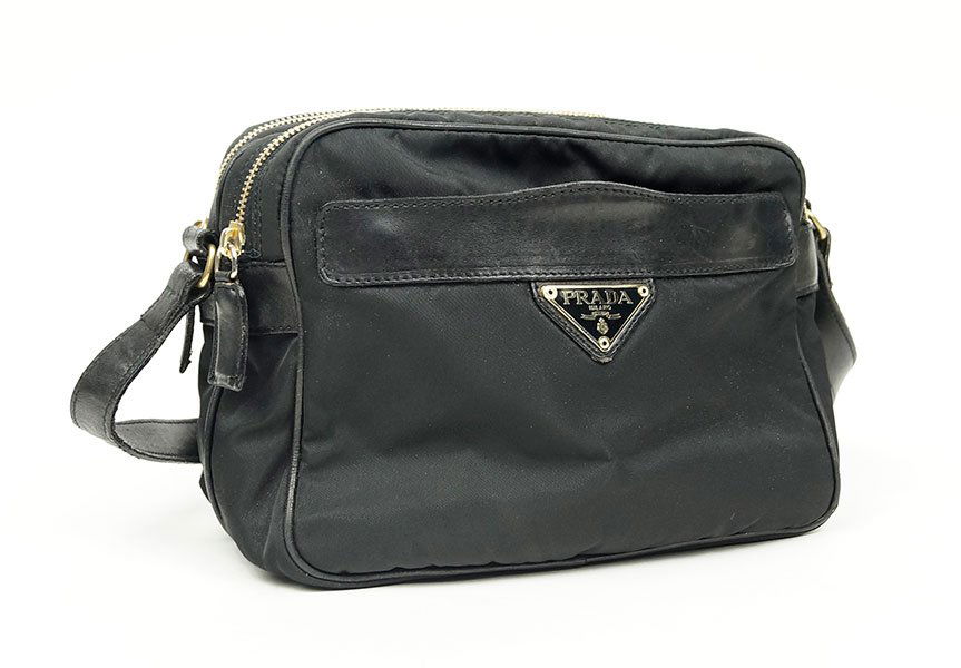 A Prada Black Nylon Crossbody Bag.: A Prada Black Nylon Crossbody Bag. Bearing goldtone hardware, a front zipper pocket, and a leather strap 6" x 8.5"