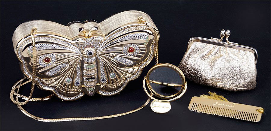 A Judith Leiber Butterfly Minaudiere.: A Judith Leiber Butterfly Minaudiere. White rhinestone and multi-colored glass adorn the butterfly form evening bag. Interior conceals a hand mirror, comb, and coin purse 3.5" x 6" x 2"