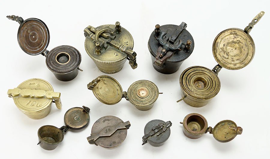A Collection of Partial Nesting Weight Sets.: A Collection of Partial Nesting Weight Sets. Group of 10 lidded nesting weights, all have a weight or two missing