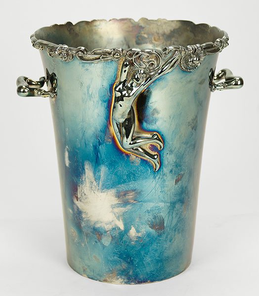 An American Meriden Silverplate Ice / Champagne Bucket.: An American Meriden Silverplate Ice / Champagne Bucket. Double handled wine cooler / bucket bears a floral border. Front of bucket bears sculptued nude woman in high relief 10" x 9.5"
