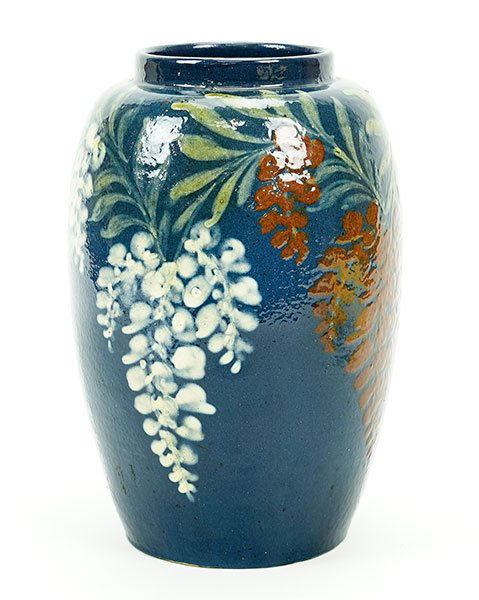 Karl & Leon Elchinger: A Vase.: Karl & Leon Elchinger: A Vase. Glazed stoneware vase is decorated with white and red floral blossoms and green leaves over a dark blue ground. Underside is impressed "Elchinger et Cie, Fireside, Made