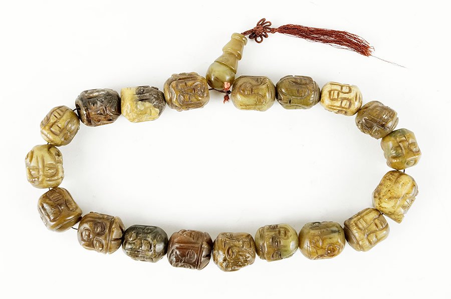 A Carved Soapstone Bead Necklace.: A Carved Soapstone Bead Necklace. Depicting faces on numerous sides Length: 22"