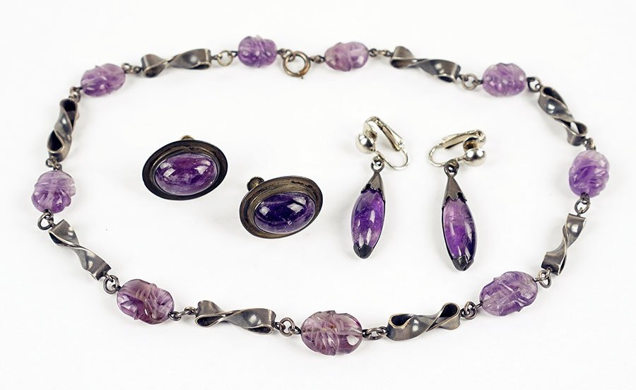 A Pair Of Jose Anton Amethyst And Mexican Silver: A Pair Of Jose Anton Amethyst And Mexican Silver Earrings. Each screwback earring contains one oval cabochon amethyst and is stamped 'Anton Plata 925 Mexico' on reverse. Together with a carved amethys