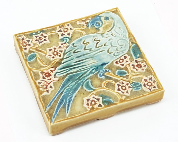 A Rookwood Pottery Trivet.: A Rookwood Pottery Trivet. Depicting a parrot on perch 1" x 5.5" x 5.5"