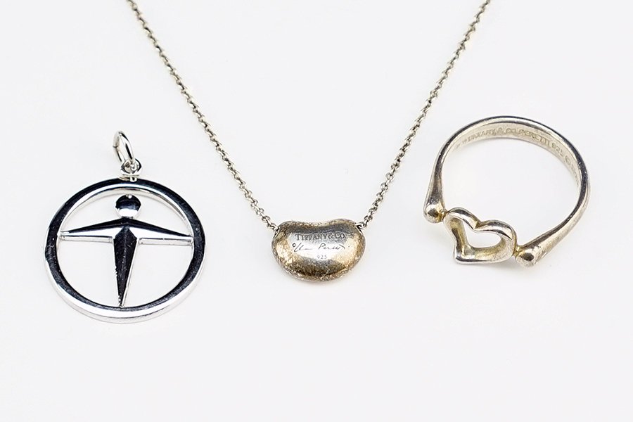 A Group of Tiffany & Company Sterilng Silver Jewelry.: A Group of Tiffany & Company Sterilng Silver Jewelry. Comprising an Elsa Peretti bean necklace, an Elsa Peretti heart ring, and a round figural pendant