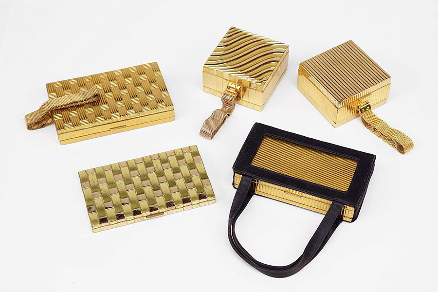 A Collection Of Four Evans Compact Clutches.: A Collection Of Four Evans Compact Clutches. Each clutch contains two compartments reavealing an assortment of hair combs, powders, lighters, mirrors, and other. Together with an Evans basketweave com
