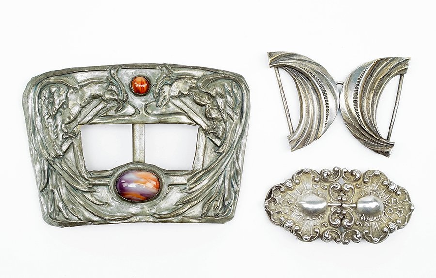 An Art Nouveau Sterling Silver Belt Buckle.: An Art Nouveau Sterling Silver Belt Buckle. Together with a French crescent form belt buckle and an additional Art Nouveau belt buckle containing two paste beads Largest Width: 4.25"