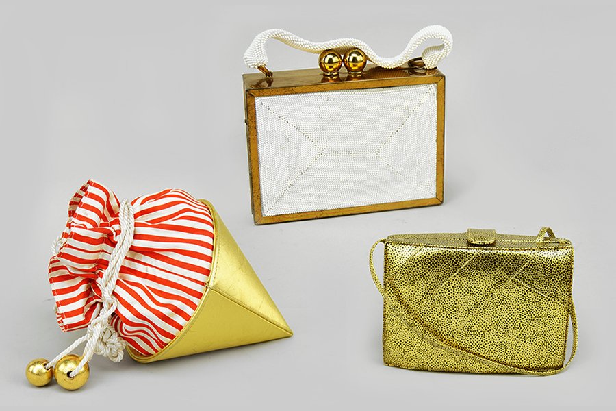 A Paloma Picasso Metallic Cone Form Evening Bag.: A Paloma Picasso Metallic Cone Form Evening Bag. With red and white stripe lining and drawstring closure. Together with a Barbara Bolan goldtone shoulder bag and a rectangular goldtone evening bag bea