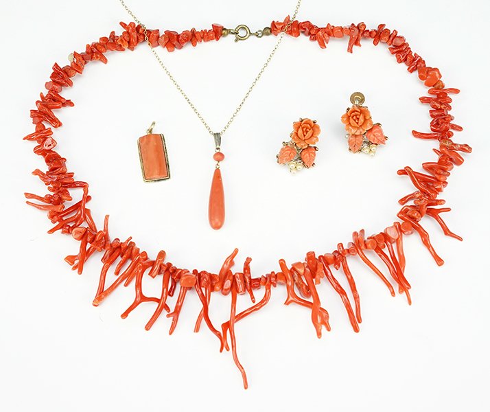 A Collection of Coral Jewelry.: A Collection of Coral Jewelry. Comprising a stick coral necklace, a coral drop pendant, a pair of coral screwback earrings, and a coral pendant