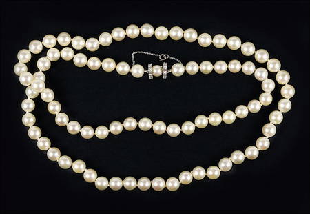 A Diamond and Pearl Necklace.: A Diamond and Pearl Necklace. Single strand cultured pearl necklace with a diamond and 14 karat white gold clasp. Pearls are approximately 8.5mm - 9mm Length: 31"