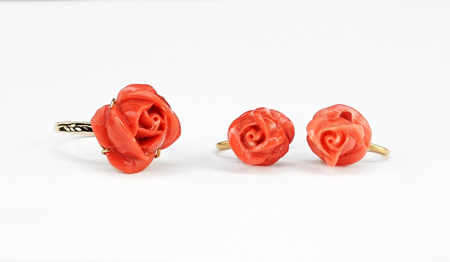 A Coral and 14 Karat Yellow Gold Ring.: A Coral and 14 Karat Yellow Gold Ring. 14 karat yellow gold mounting containing a carved coral flower blossom. Together with a pair of carved coral and 18 karat yellow gold screwback earrings (wt: 5.2
