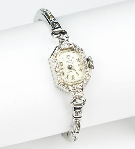 A Lady's Diamond and Platinum Watch.: A Lady's Diamond and Platinum Watch. Platinum watch face contains 24 round diamonds. Interior contains a 17 jewel Eloga movement. Bracelet is white metal and rhinestones. Susanin's will not comment on