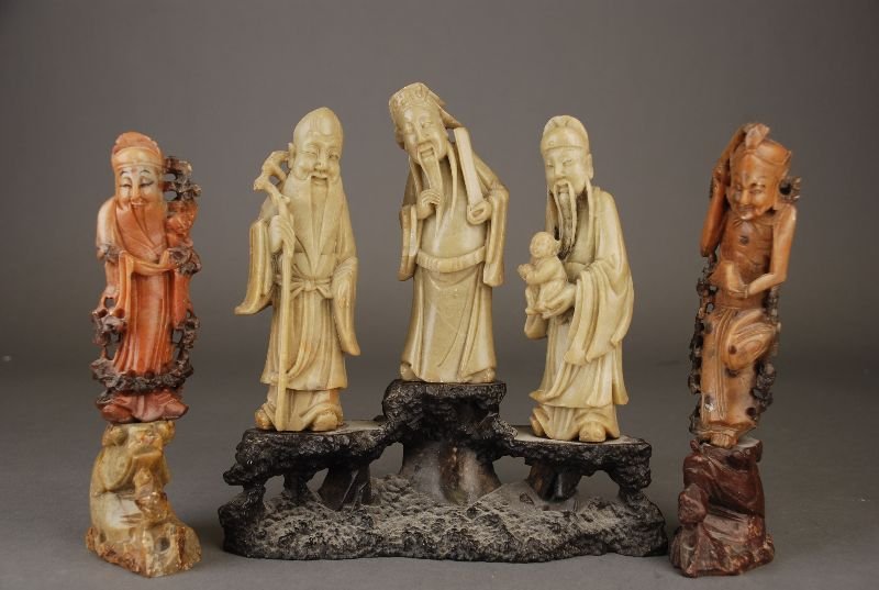C19th Chinese soapstone figural five group carved with: C19th Chinese soapstone figural five group carved with Shoulao, Fuxing & Luxing holding their attributes, together with further two soapstone standing figures of immortals 20.2H max (3)